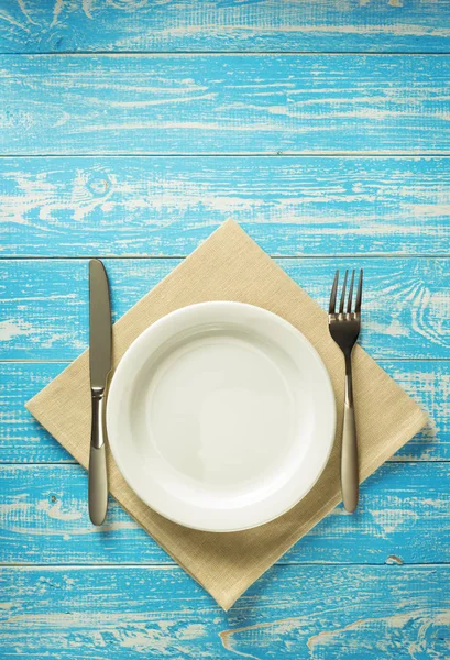 Assiette, couteau et fourchette sur fond rustique — Photo