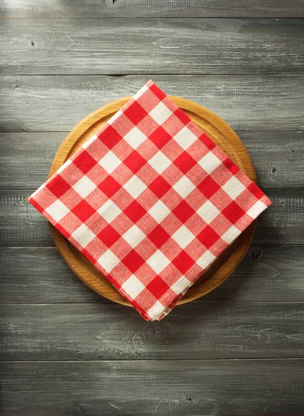 Napkin and board on wooden background — Stock Photo, Image