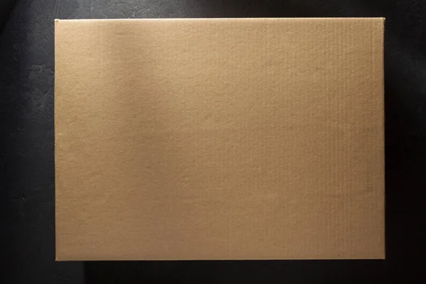 Cardboard box on black — Stock Photo, Image