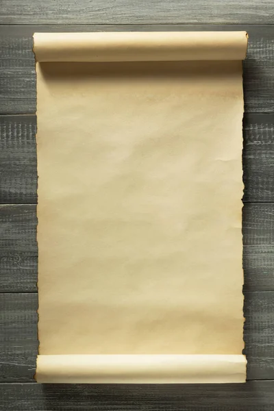 Свиток пергамента на деревянном фоне — стоковое фото