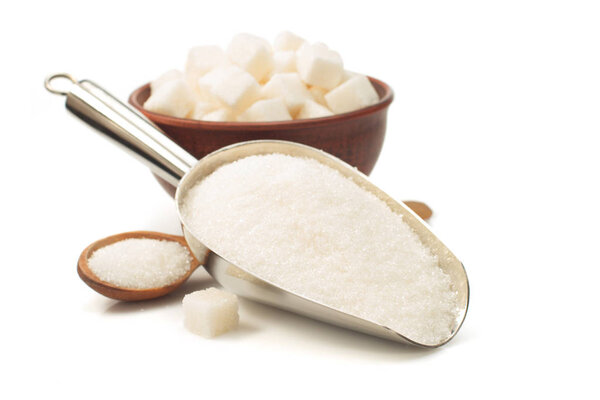 granulated sugar in scoop on white 