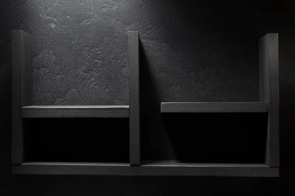 Houten plank bij zwarte muur — Stockfoto