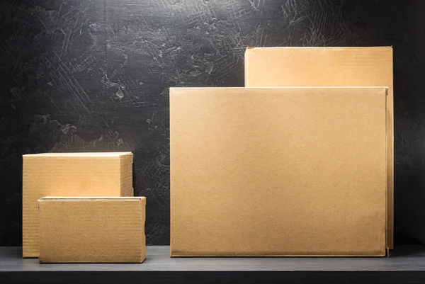 Cardboard boxes on wooden shelf — Stock Photo, Image