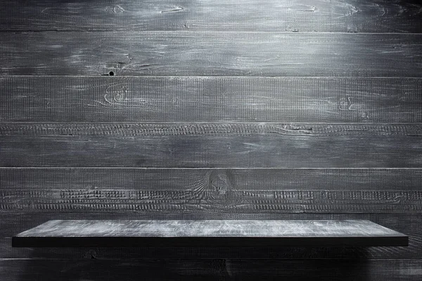Деревянная полка на фоне черной стены — стоковое фото