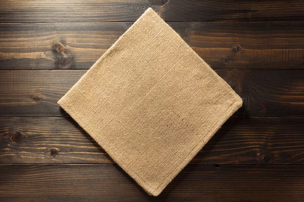 在木头上的粗麻布麻布餐巾 — 图库照片