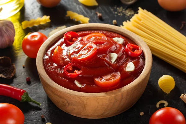 Sauce tomate dans un bol sur fond noir — Photo