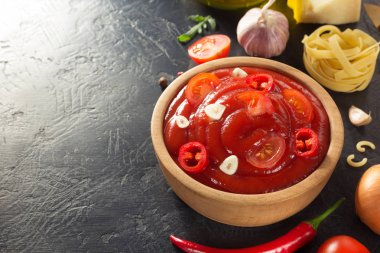 siyah arka plan üzerine bir kapta domates sosu