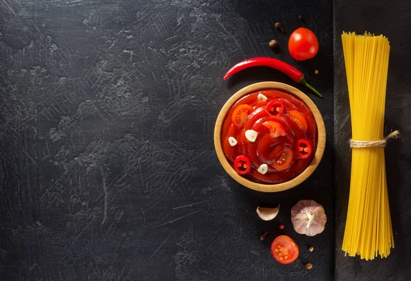 Tomatsås i skål på svart bakgrund — Stockfoto