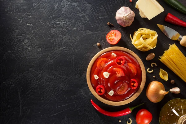 Tomatsås i skål på svart bakgrund — Stockfoto