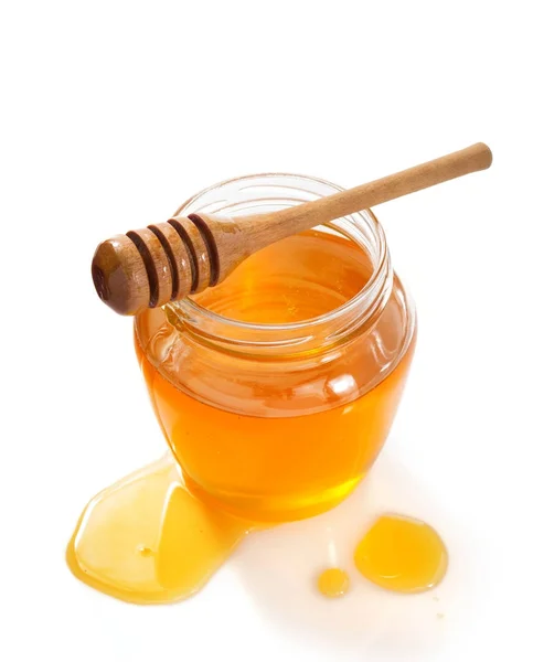 Glass jar full of honey and dipper — Stock Photo, Image