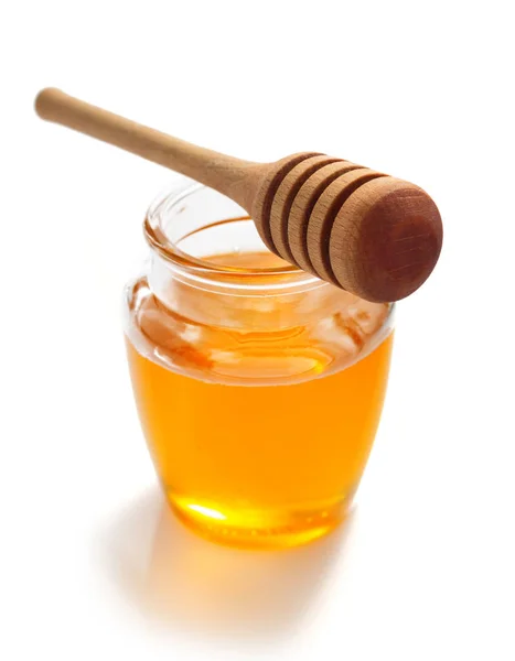 Jarra de mel e dipper no fundo branco — Fotografia de Stock