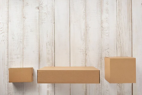 Kartonové krabice na dřevěné pozadí — Stock fotografie