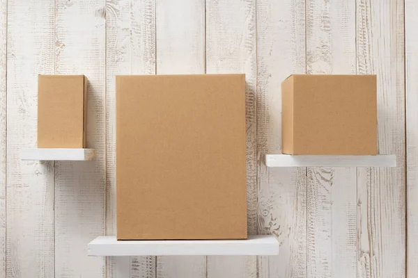 Caixa de papelão na prateleira de madeira — Fotografia de Stock