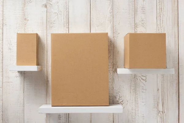 Cardboard box on wooden shelf — Stock Photo, Image