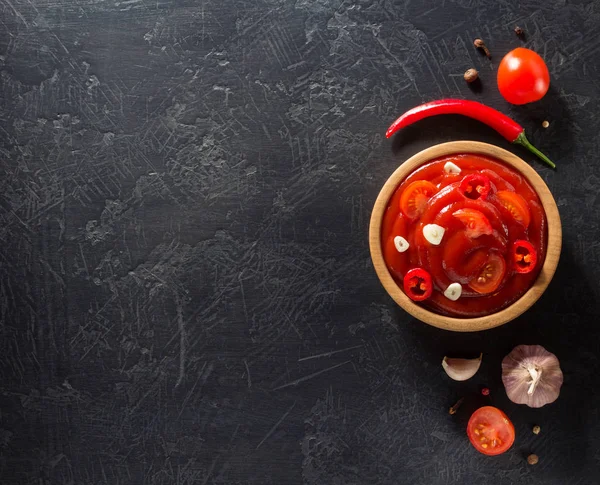 Molho de tomate em tigela no fundo preto — Fotografia de Stock
