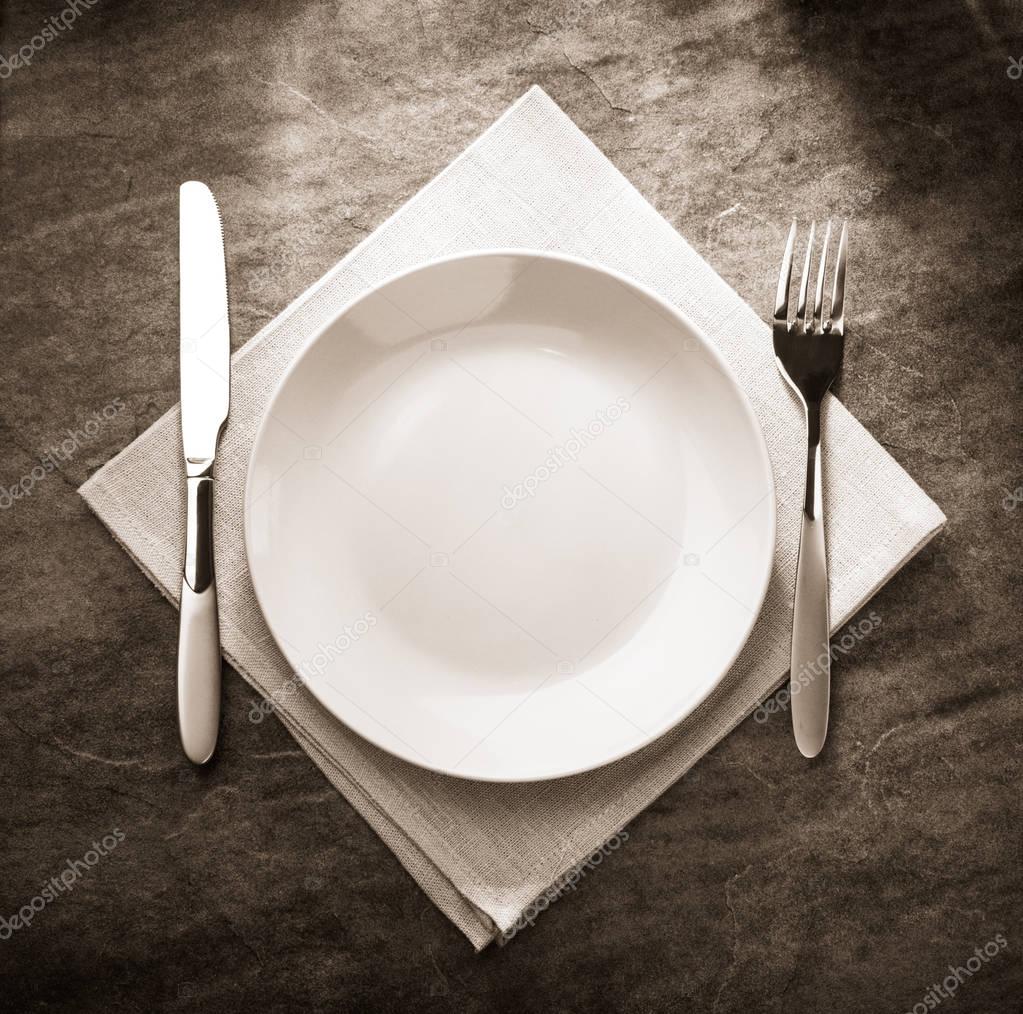 plate, knife and fork on napkin