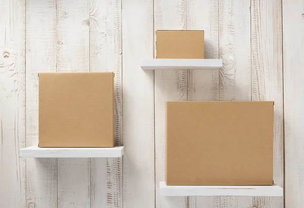Cardboard box on wooden shelf — Stock Photo, Image