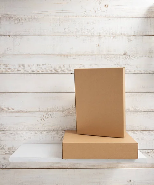 Cardboard box on wooden shelf — Stock Photo, Image