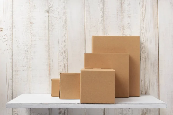 Kartonnen doos op houten plank — Stockfoto