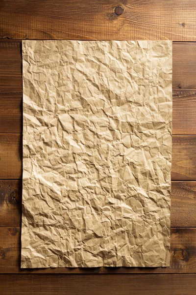 Морщинистая бумага на деревянной доске — стоковое фото