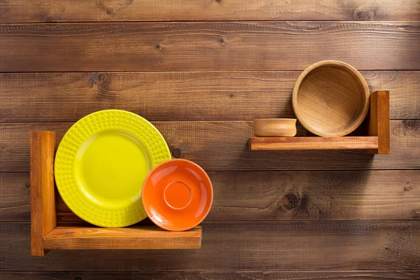 Plate at kitchen wooden shelf at wall — Stock Photo, Image