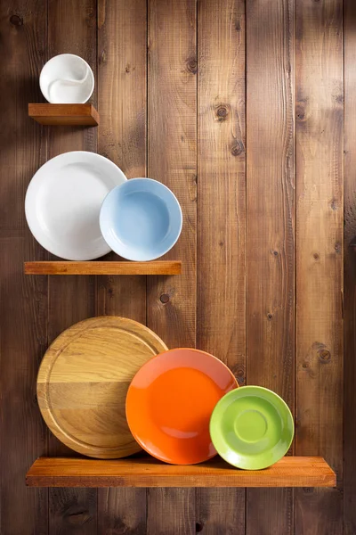 Plate at kitchen wooden shelf at wall — Stock Photo, Image