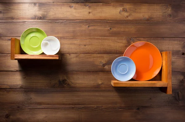 Plate at kitchen wooden shelf at wall — Stock Photo, Image