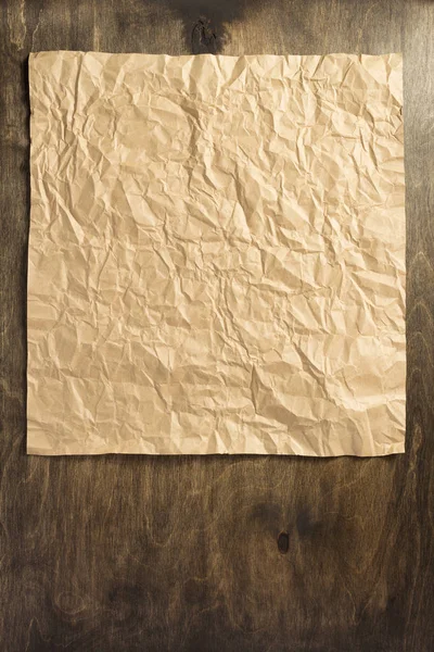 Морщинистая бумага на деревянном фоне — стоковое фото