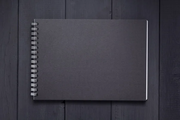 黑色木制背景的纸本笔记本 — 图库照片