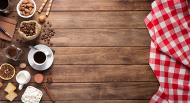 Tahta arka planda bir fincan kahve ve fasulye.