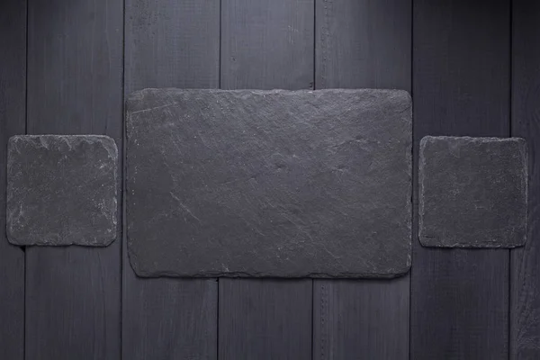 Placa de piedra de pizarra o letrero de pared en el fondo de madera —  Fotos de Stock