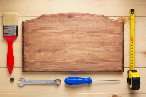 Gereedschap op plank houten bordtafel achtergrond — Stockfoto