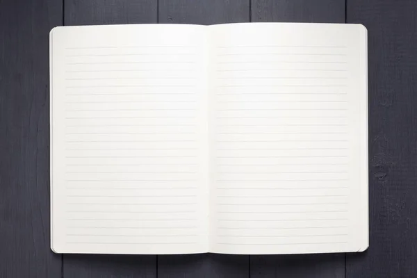 Papel notepad ou notebook em fundo de madeira preta — Fotografia de Stock