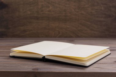 Ahşap masa arkaplan tablosunda not defteri veya kağıt kitap