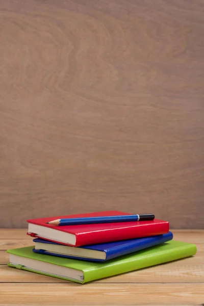 ノートパッドや紙のノートブックを木のテーブルの背景表に — ストック写真