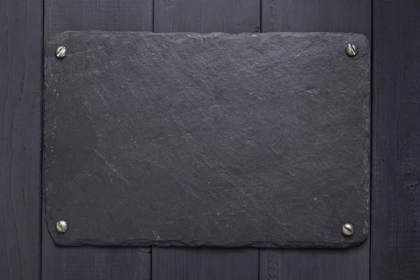黑色木制背景纹理表面的石板铭牌或壁牌 带有螺丝 — 图库照片