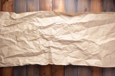 Ahşap duvarda veya masa arkasında buruşuk kağıt