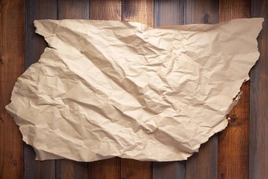 Ahşap duvarda veya masa arkasında buruşuk kağıt