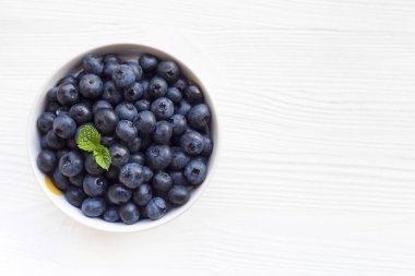 Ahşap bir masa, üstten görünüm üzerinde bir kasede yaban mersini