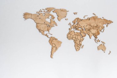 Beyaz bir duvarda tahta bir dünya haritası. Coğrafya konsepti. Seyahat için arka plan. Lojistik ve ulaşım, dünya çapında iş. Tüm kıta. Avrupa, Amerika, Avustralya ve Asya.