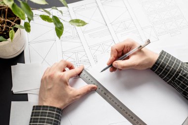 Ui / Ux web sitesi tasarımcısı prototip, çerçeve ve gelecek projenin kablo çizimini çiziyor. Yaratıcı kullanıcı deneyimi konsept web sitesi şablonu. Tasarımcı çalışma alanı, arayüz geliştirme. Tasarım stüdyosu