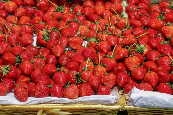 Tezgahta taze kırmızı sulu çilekler var.
