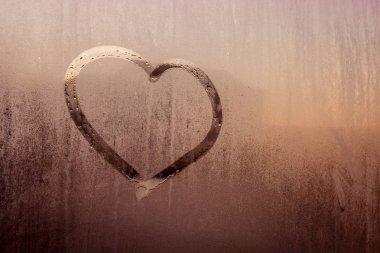 Bir kalp çizilir, bir ıslak camına bir arka plan bulanık kırmızı renk