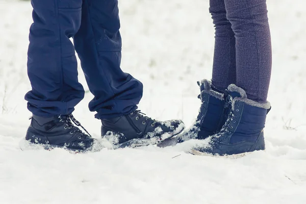 Dos jóvenes amantes de pie en un día de invierno en la nieve, girando a e — Foto de Stock