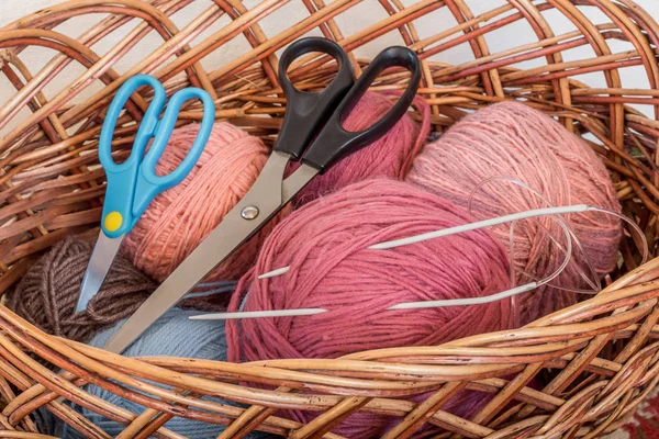 Em um cesto colocar bobinas de fios, agulhas de tricô e tesoura _ — Fotografia de Stock