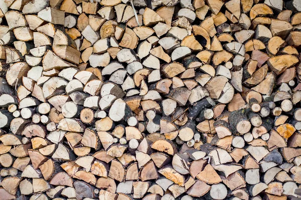 Neatly stacked firewood, fuel in the cold winter, a pattern for — Stock Photo, Image