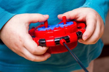  boy holds  toy control panel, mastering modern technologies_