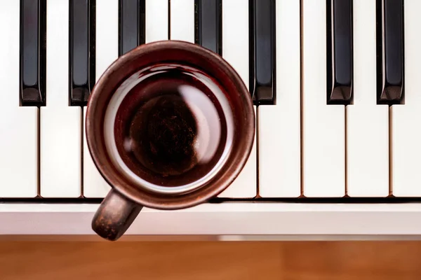 Tasse Kaffee auf Klaviertasten, Stärkungsgetränk gegen Müdigkeit, — Stockfoto