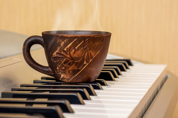  cup of tea on the piano keys,  break during music lessons_