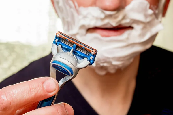 The man is going to shave, he is holding  shaving machine-tool i — Stock Photo, Image